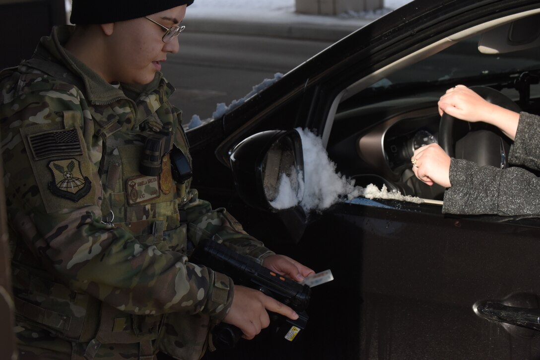 Airman 1st Class Gabriella Sepulveda, a 28th Security Forces Squadron response force member, verifies a common access card at the Liberty Gate on Ellsworth Air Force Base, S.D., Dec. 4, 2018. Each person that comes through the gate gets checked for proper authorization, correct seatbelt wear and that their vehicle has registration on the plates. (U.S. Air Force photo by 2nd Lt. Joshua Sinclair)