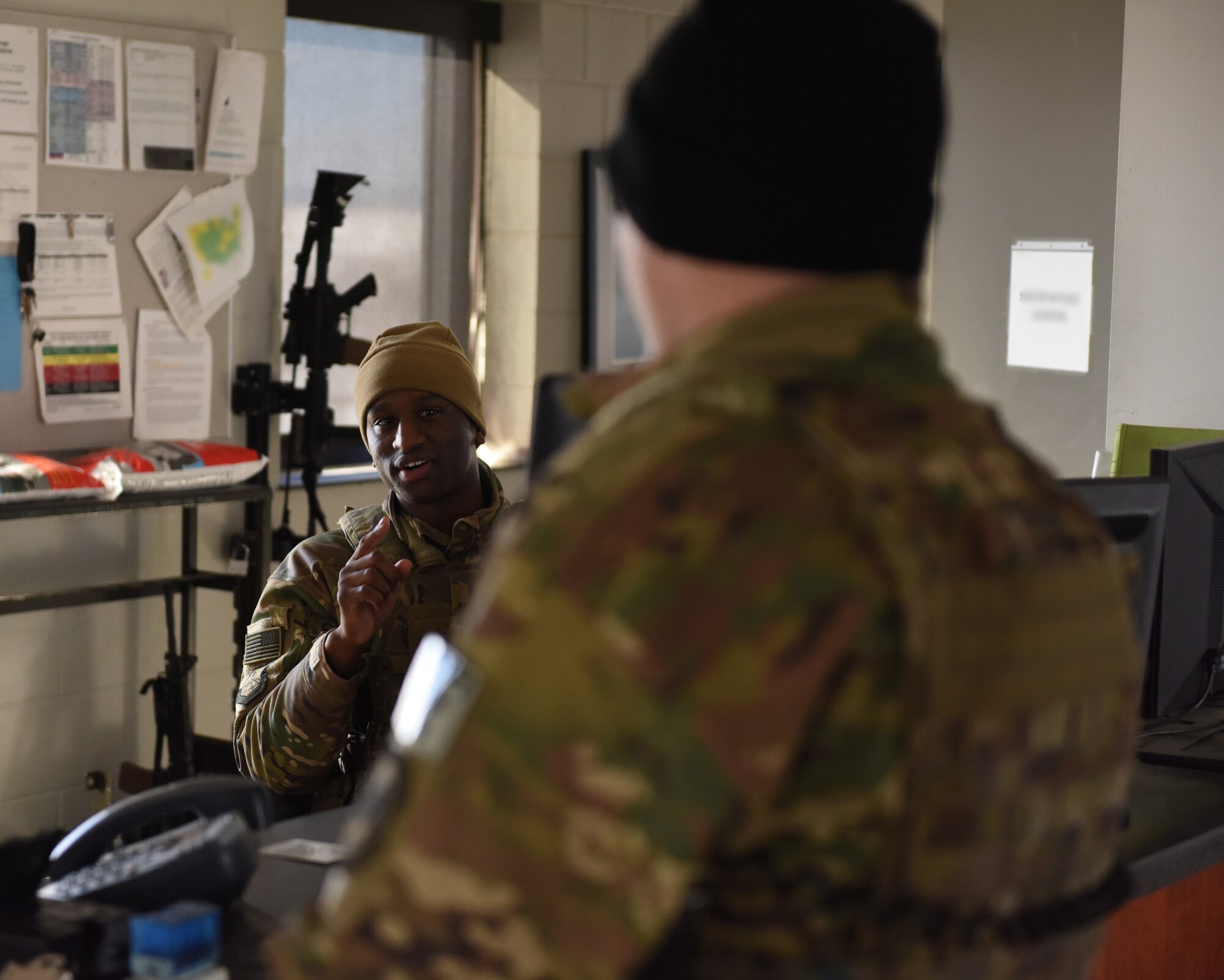 Staff Sgt. Omari-Darnell Ferguson and Senior Airman Taylor Tschida, both 28th Security Forces Squadron alarm monitors, talk inside the gate shack at the Liberty Gate on Ellsworth Air Force Base, S.D., Dec. 4, 2018. Each person that comes through the gate gets checked for proper authorization, correct seatbelt wear and that their vehicle has registration on the plates. (U.S. Air Force photo by 2nd Lt. Joshua Sinclair)