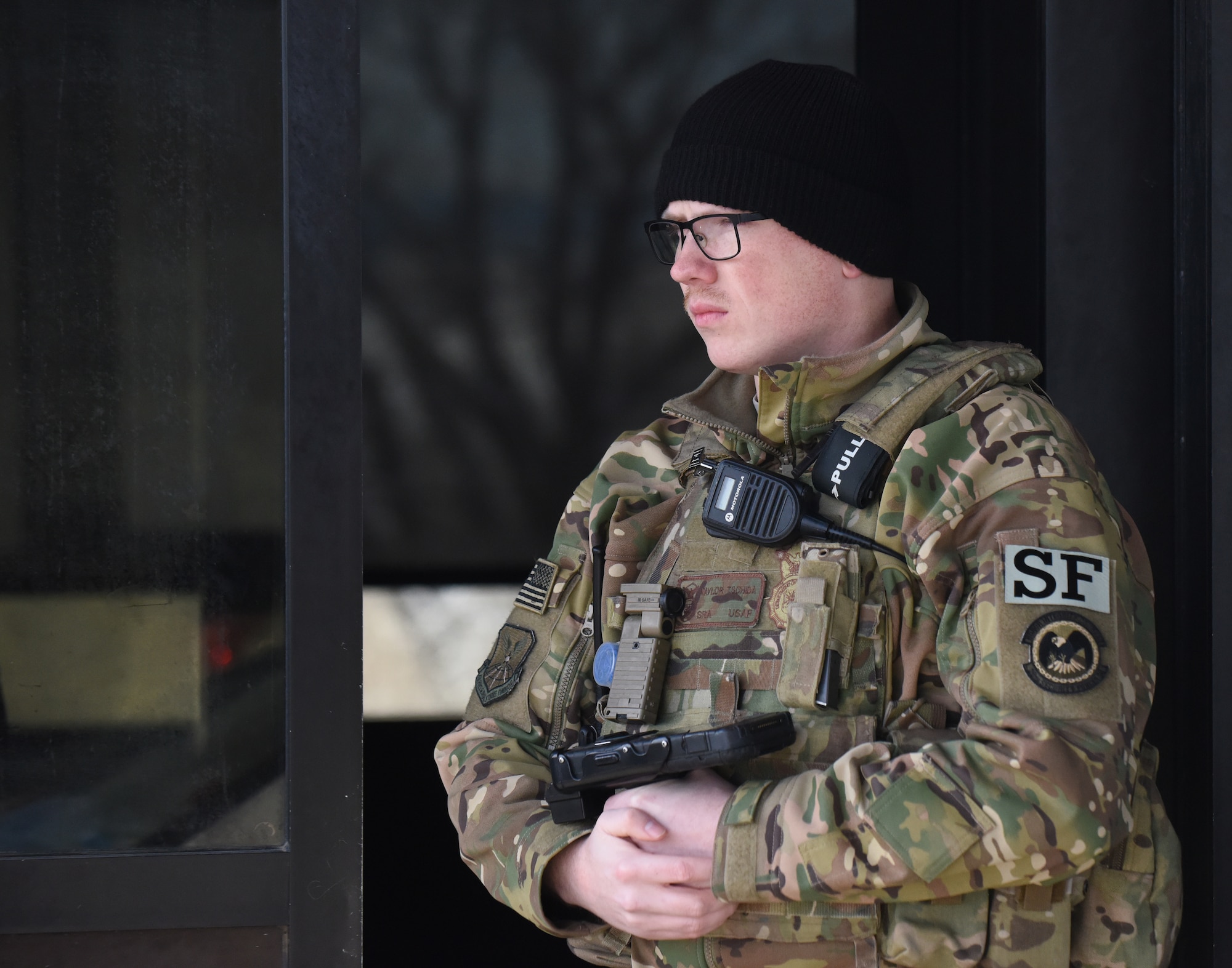 Senior Airman Taylor Tschida, a 28th Security Forces Squadron alarm monitor, stands outside the Liberty Gate waiting for the next car to approach for entry to Ellsworth Air Force Base, S.D., Dec. 4, 2018. Each person that comes through the gate gets checked for proper authorization, correct seatbelt wear and that their vehicle has registration on the plates. (U.S. Air Force photo by 2nd Lt. Joshua Sinclair)