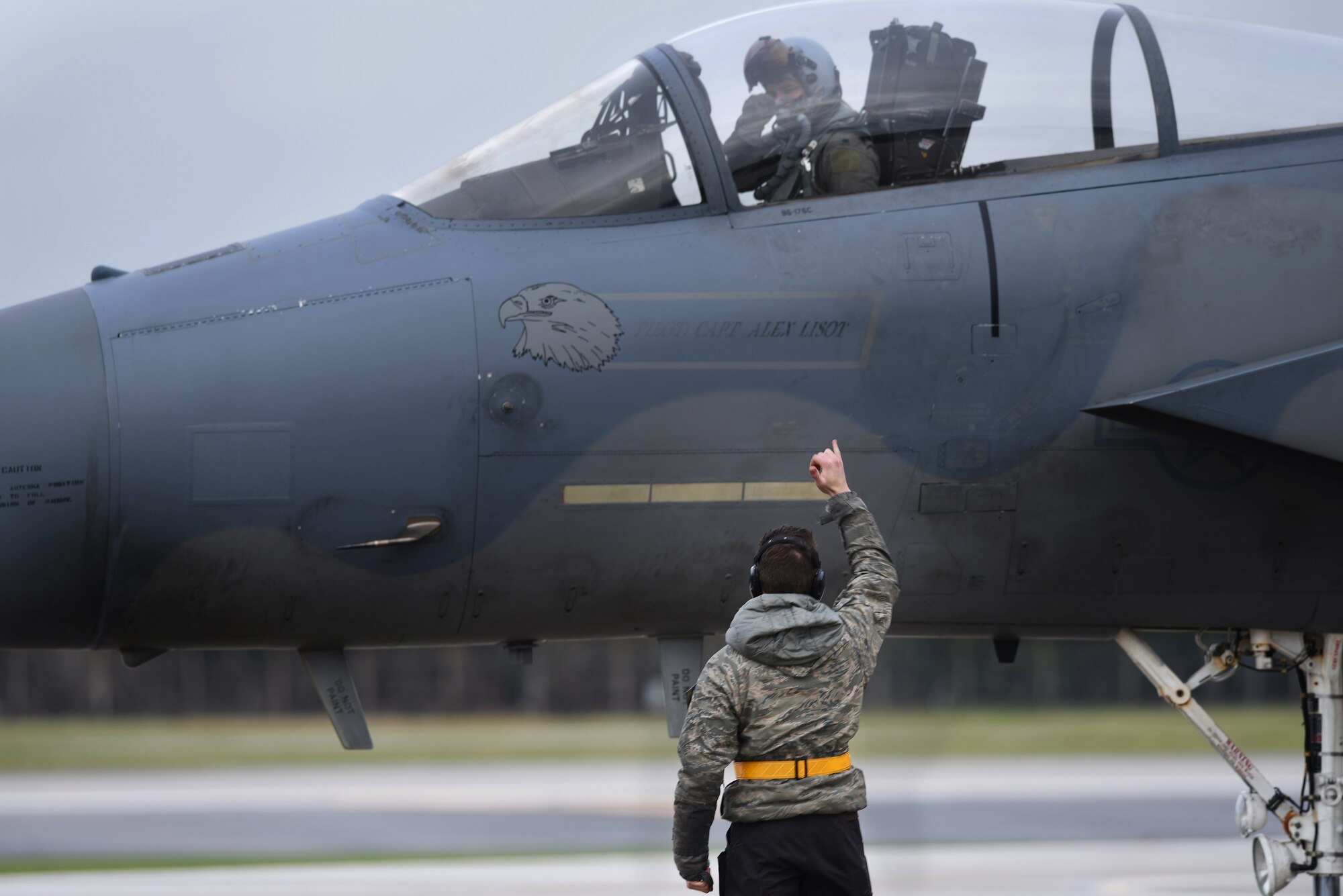 A maintainer assigned to the 48th Maintenance Group marshalls an F-15C Eagle assigned to the 493rd Fighter Squadron at Royal Air Force Lakenheath, England, Dec. 18, 2018. The 48th Maintenance Group is responsible for all organizational and intermediate level maintenance for F-15C, F-15D, F-15E Strike Eagle aircraft, engines, munitions and support equipment used to accomplish U.S. Air Forces in Europe and Africa, U.S. European command and NATO commitments and taskings. (U.S. Air Force photo by Airman 1st Class Shanice Williams-Jones)