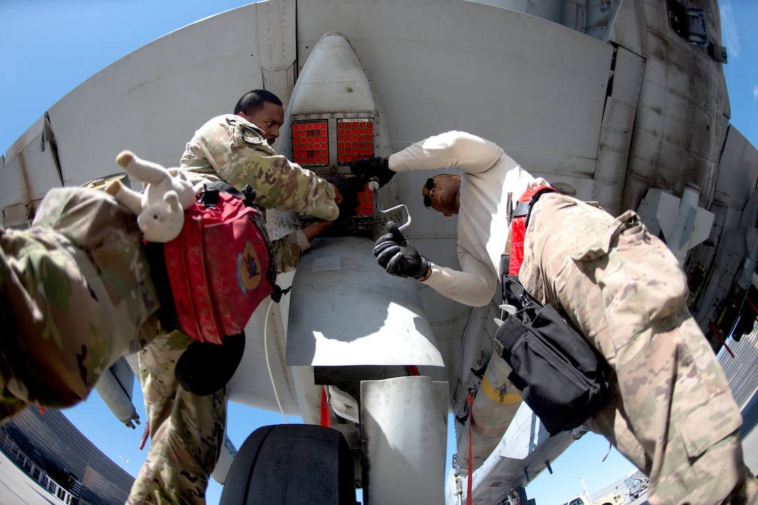 Airmen load munitions into a military aircraft.
