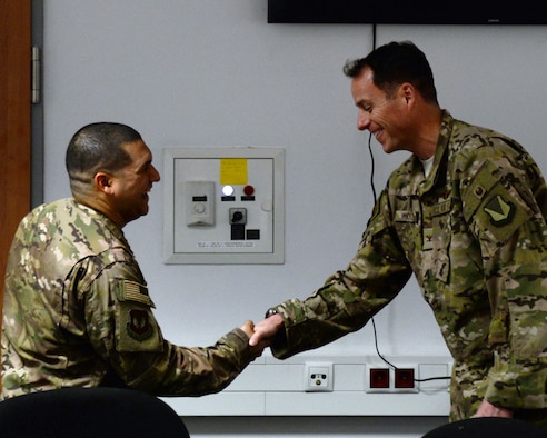 U.S. Air Force Staff Sgt. Ricardo B. Porto, 786th Civil Engineer Squadron explosive ordnance disposal non-commissioned officer in charge, left, receives recognition from Col. Joseph Wenckus, 86th Airlift Wing vice commander on Ramstein Air Base, Germany, Dec. 20, 2018.