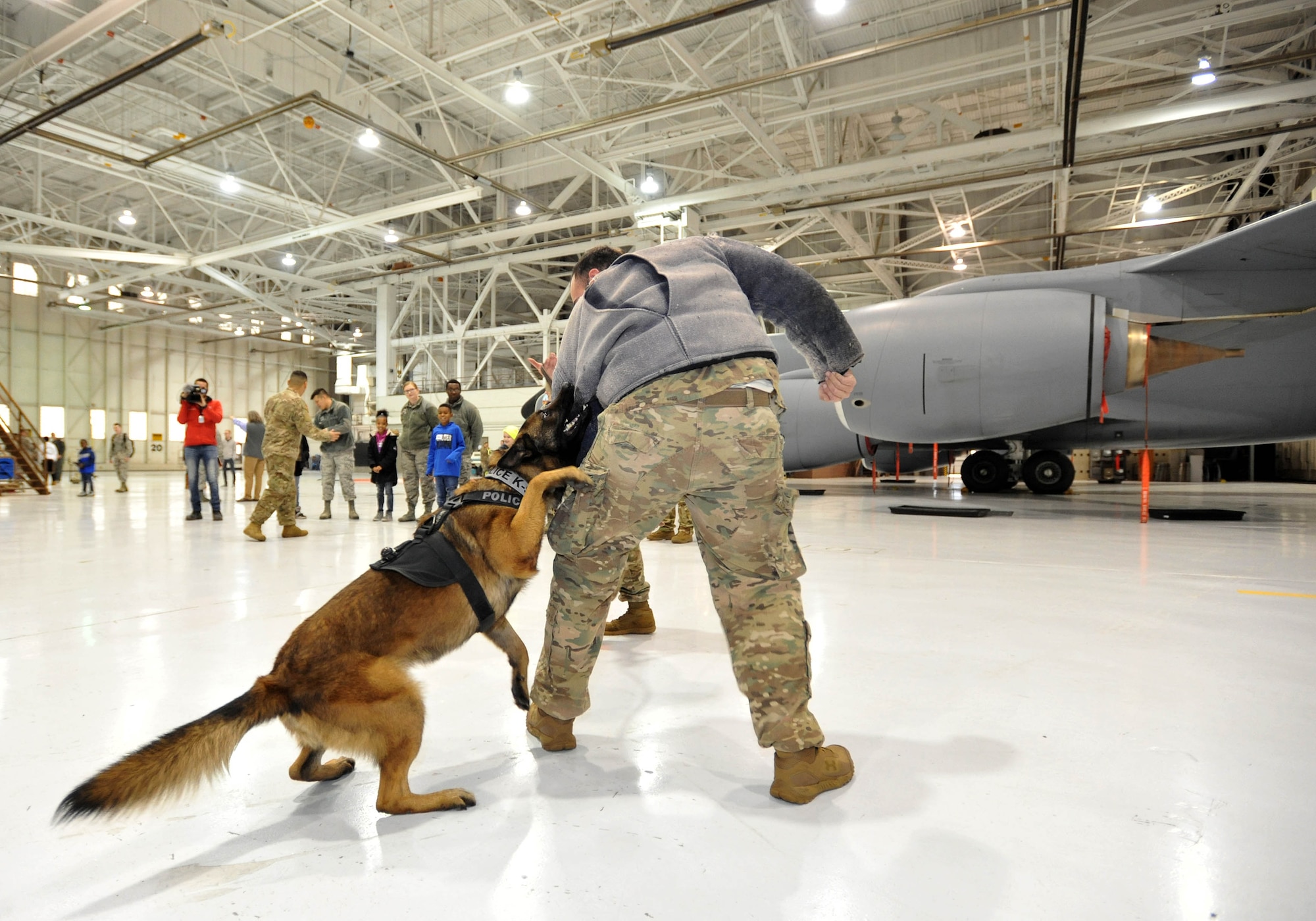 Staff Sgt. Robert Johnson, 22nd Security Forces Squadron military working dog handler, demonstrates how an MWD is trained and how they attack Dec. 19, 2018, at McConnell Air Force Base, Kansas. Sani, a brand new military working dog, was showcased to the children to demonstrate how McConnell uses MWDs to deter criminals and how security forces can apprehend those breaking the law. (U.S. Air Force photo by Staff Sgt. David Bernal Del Agua)