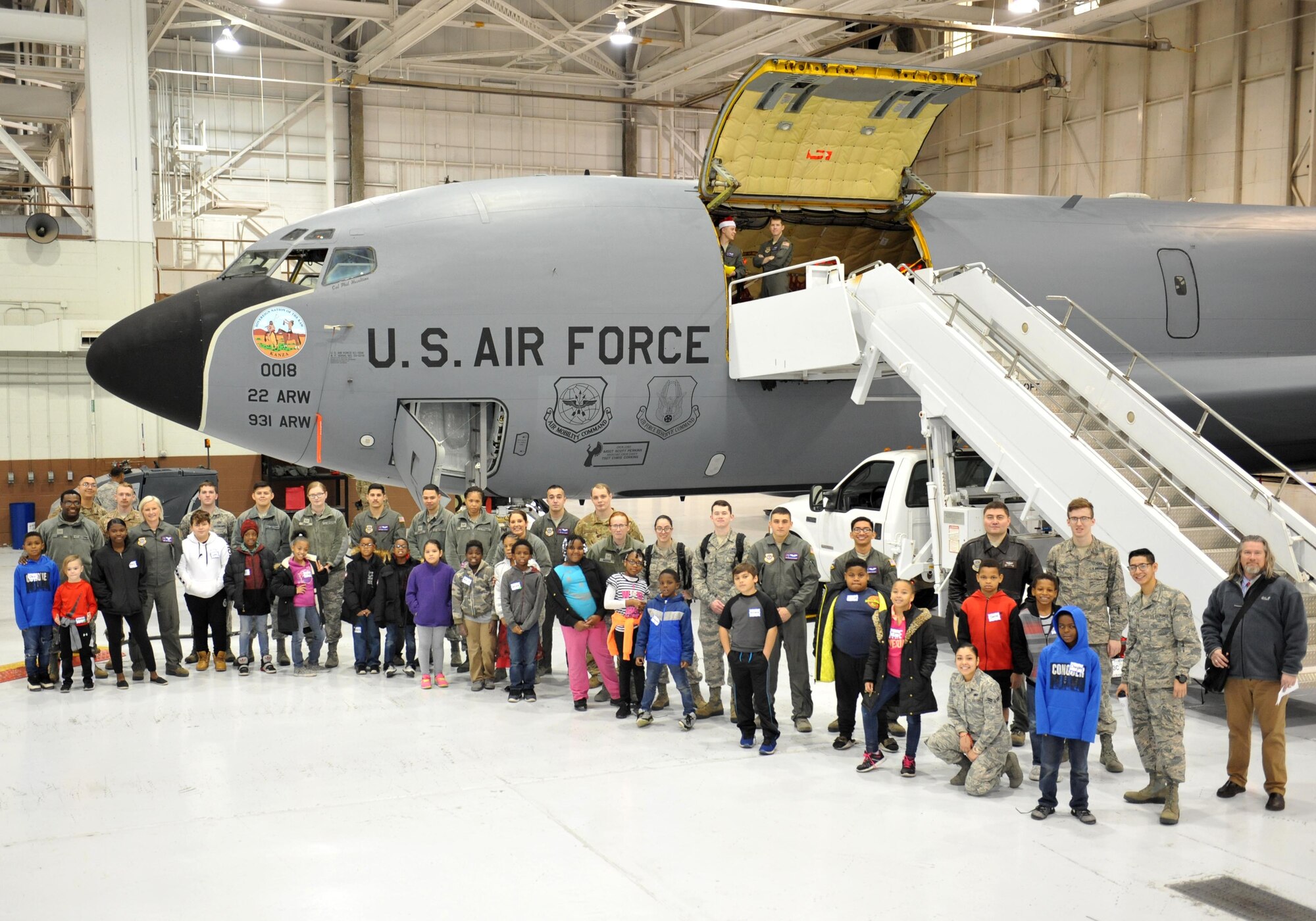 Airmen pose for a photo with children from Big Brothers Big Sisters Dec. 19, 2018, at McConnell Air Force Base, Kansas. Operation Santa brought children and Airmen together, where they toured static displays, build gingerbread houses and received little gifts. (U.S. Air Force photo by Staff Sgt. David Bernal Del Agua)