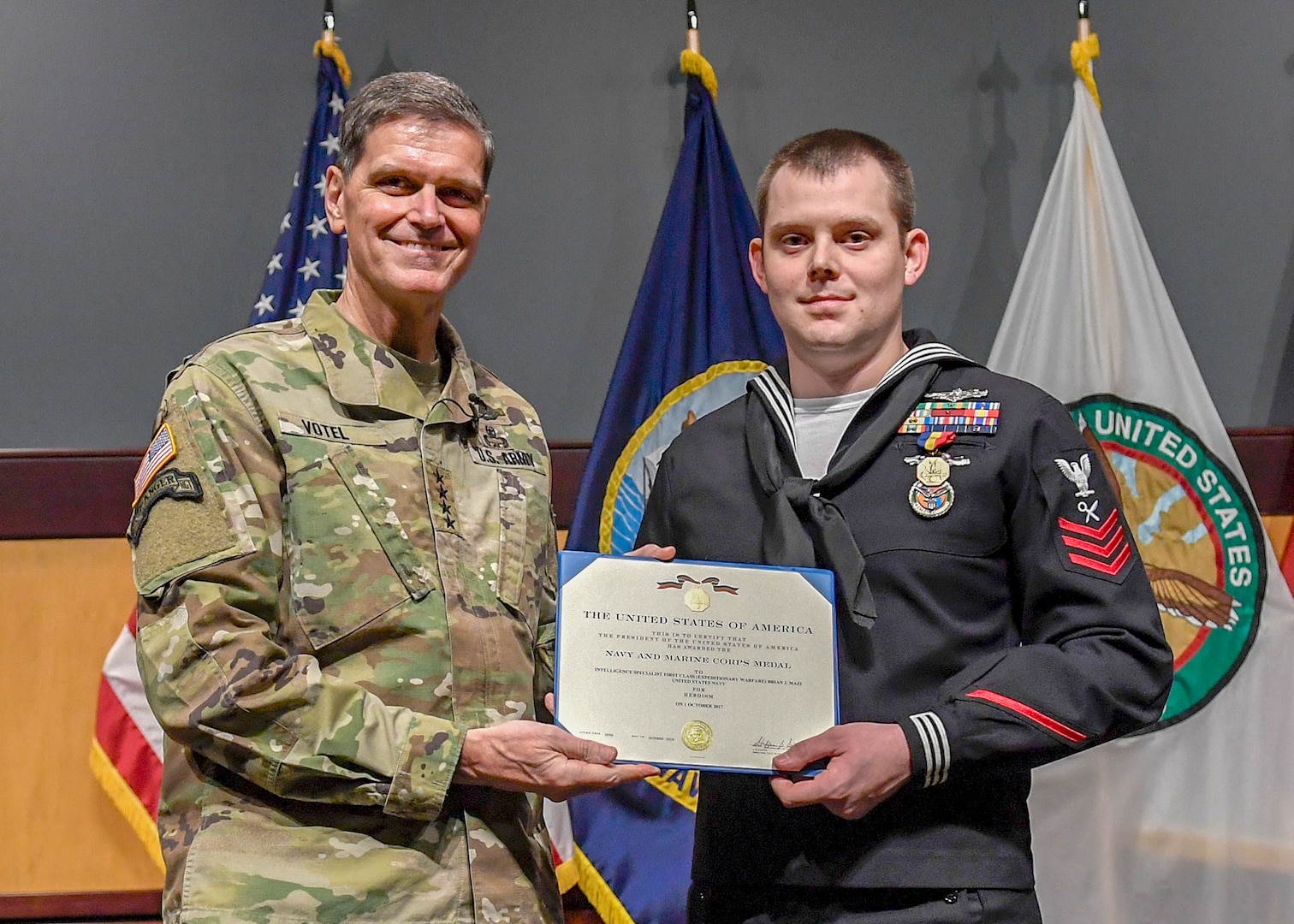 U.S. Army Gen. Joseph Votel, U.S. Central Command commander (left), presents U.S. Navy Petty Officer 1st Class Brian Mazi, USCENTCOM intelligence specialist, with the Navy-Marine Corps Medal on Dec. 18. Mazi was recognized for his heroism during the October 2017 tragedy that left 58 dead and more than 500 wounded at a country music festival in Las Vegas. The award falls between the Distinguished Flying Cross and the Bronze Star in order of merit.