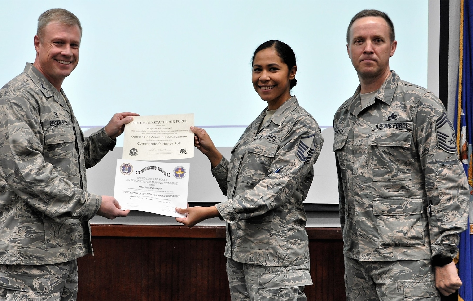 Master Sgt. Tainell Pettengill accepts distinguished technical training graduate and commander’s honor roll certificates from 340th Flying Training Group Commander Col. Allen Duckworth and 340th FTG group superintendent, Chief Master Sgt. Scott Goetze during the Dec. 13-14 mandatory unit training assembly (or MUTA) at Joint Base San Antonio, Texas. (U.S. Air Force photo by Tech. Sgt. Brianne Blackstock)