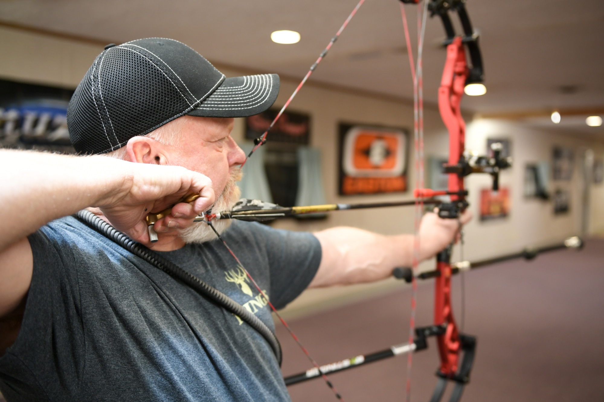 Wayne Willey aims his compound bow at a three-spot target during a Hill Archery Club league night Dec. 13, 2018, at Hill Air Force Base, Utah. Besides access to the clubhouse and ranges 24/7, Hill club members are also invited to participate in several archery events throughout the year. (U.S. Air Force photo by Cynthia Griggs)