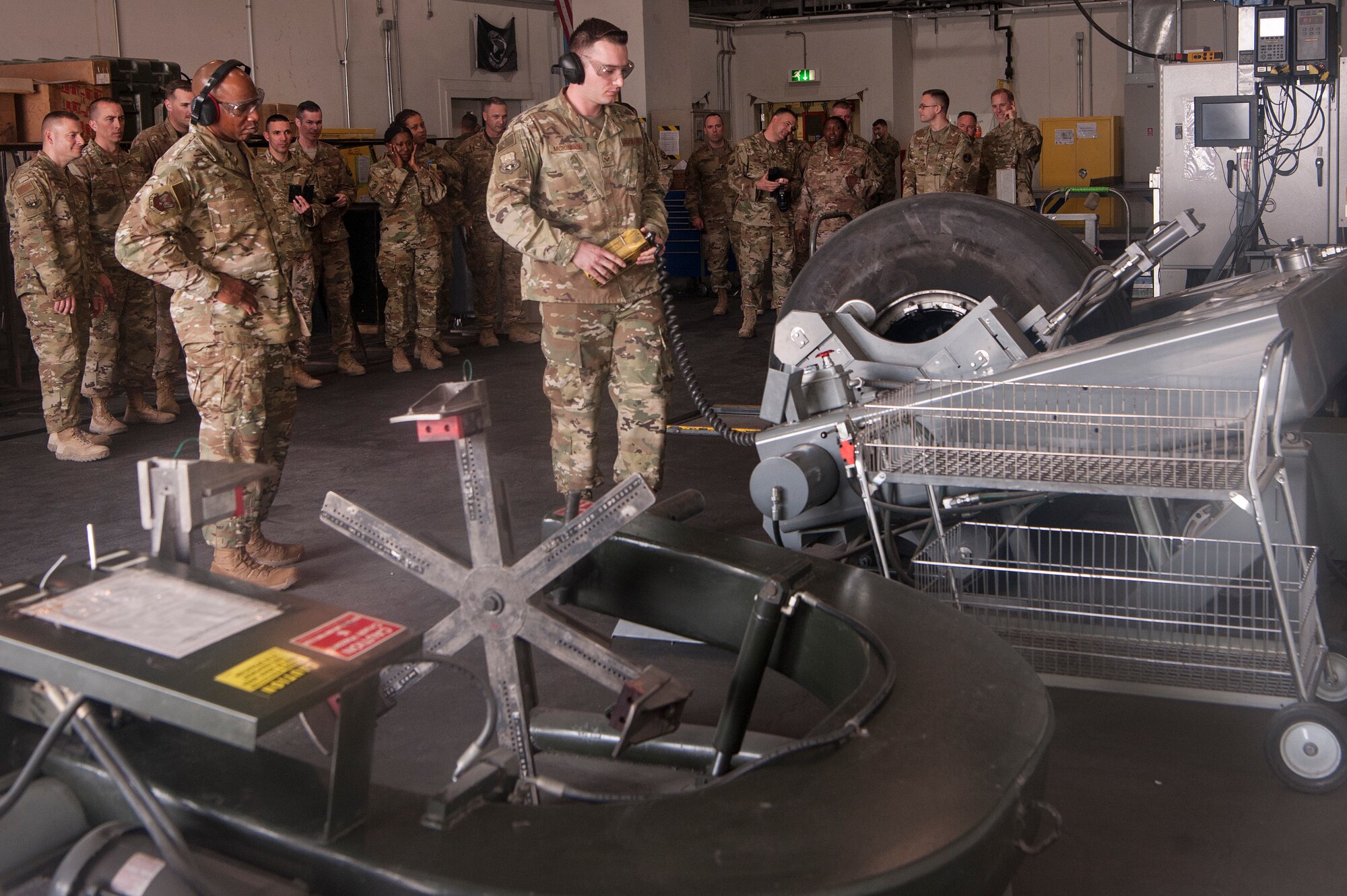 Senior Airman Kane McKinnon, 379th Expeditionary Maintenance Squadron crew chief, shows Chief Master Sgt. of the Air Force Kaleth O. Wright, how to operate equipment at the squadron’s wheel and tire shop at Al Udeid Air Base, Qatar, Dec. 20, 2018. McKinnon demonstrated some of the equipment used in the shop for Wright while also explaining various aspects of his job. (U.S. Air Force photo by Tech. Sgt. Christopher Hubenthal)