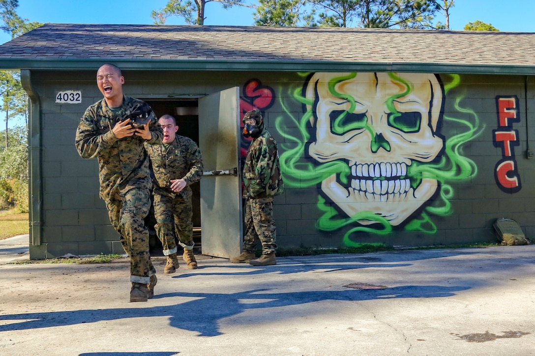Marine Corps recruits run out of a gas chamber.