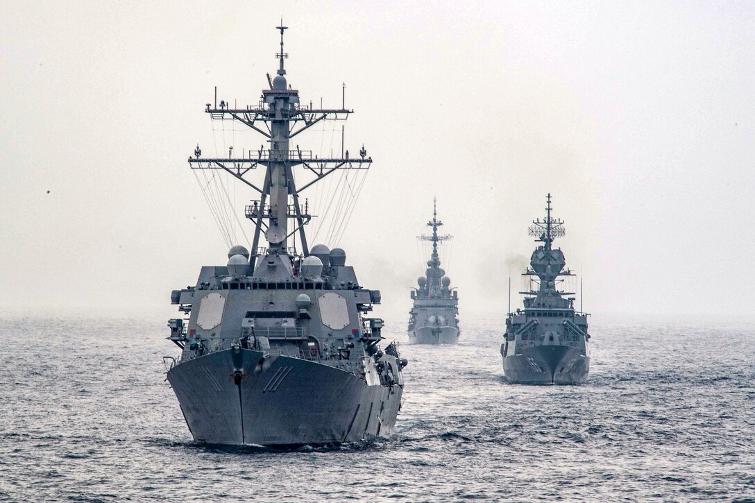 Three naval vessels travel in the Arabian Sea.