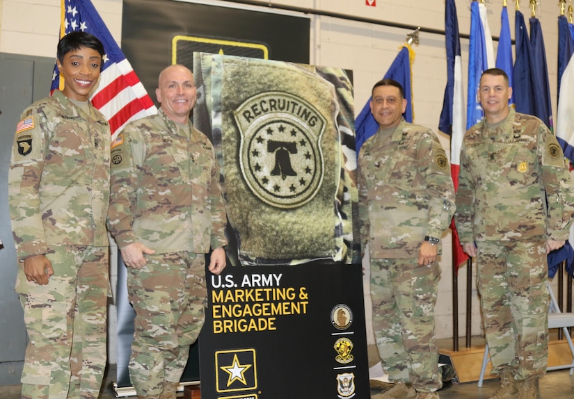 From left to right, USAREC Command Sergeant Major, CSM Tabitha A. Gavia, and USAREC Commander, Maj. Gen. Frank M. Muth, join USAMEB Commander, Col. Oscar H. Pintado, and USAMEB Command Sergeant Major, CSM Steven R. Laick to unveil branding commemorating the brigade’s move to USAREC.