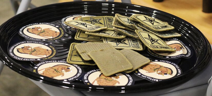 Army Marketing Brigade and Mission Support Battalion Soldiers put on the USAREC Bell shoulder patch during a ceremony Dec. 18. Pictured are the Army Staff patch and MSB logo, ‘The Workhorse Battalion.