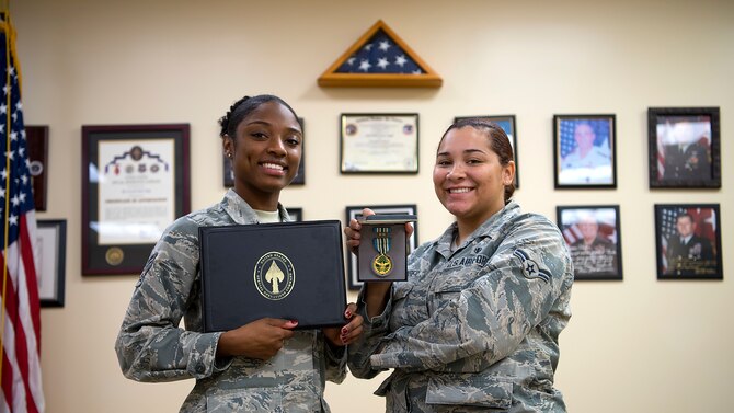 U.S. Air Force Senior Airman Ralecia Ogburn and Airman 1st Class Amari Alexander, 6th Medical Operations Squadron aerospace medical technicians display their Joint Service Commendation honors at MacDill Air Force Base, Fla., Dec. 20, 2018. Ogburn and Alexander distinguished themselves by providing urgent medical treatment and life-saving aid to a critically wounded civilian at a parachute airdrop zone.