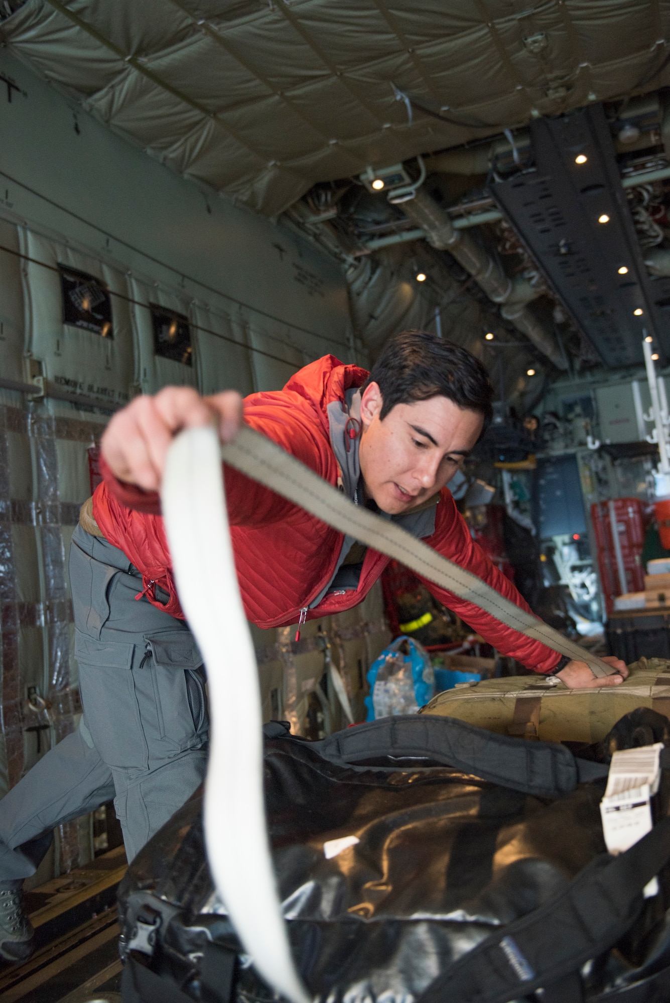 A pararescueman with the 212th Rescue Squadron secures mission-essential cargo on a C-130J "Combat King II" at Joint Base Elmendorf-Richardson, Alaska, for an aerial damage assessment Nov. 30, 2018. In a matter of hours, members of the Alaska Air National Guard's Maintenance and Operation groups turned a planned community engagement into an aerial survey of earthquake damage in Southcentral Alaska, reporting findings to the State of Alaska's Joint Operations Center.