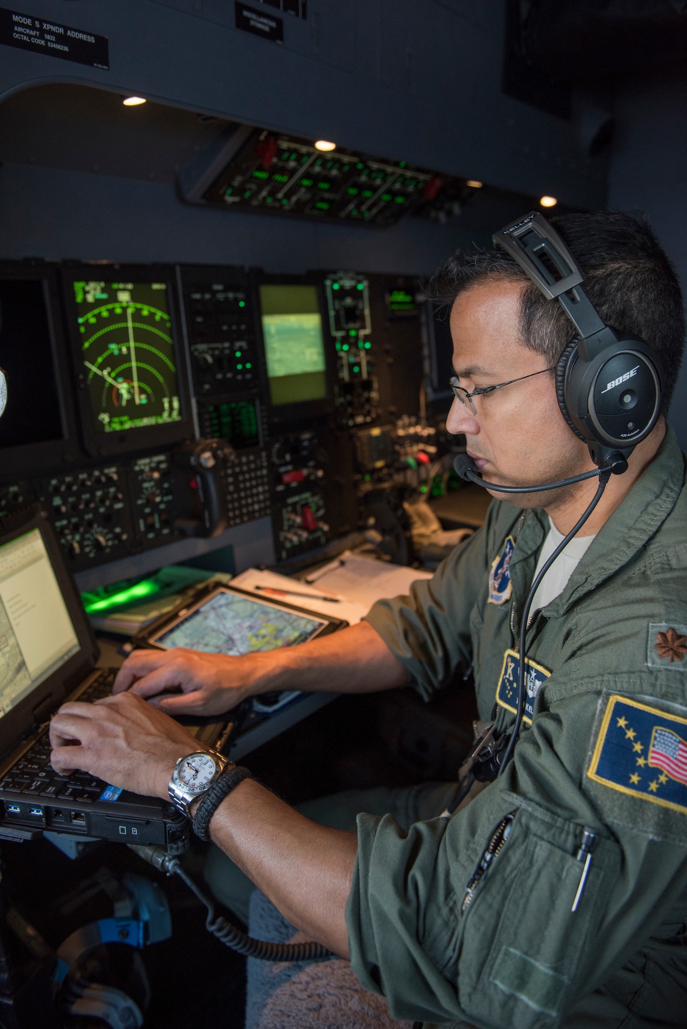 Maj. Daniel Kelley, a combat systems operator with the 211th Rescue Sqaudron, communicates vital data to the pilots during an aerial damage assessment Nov. 30, 2018, on a C-130J "Combat King II". In a matter of hours, members of the Alaska Air National Guard's Maintenance and Operation groups turned a planned community engagement into an aerial survey of earthquake damage in Southcentral Alaska, reporting findings to the State of Alaska's Joint Operations Center.