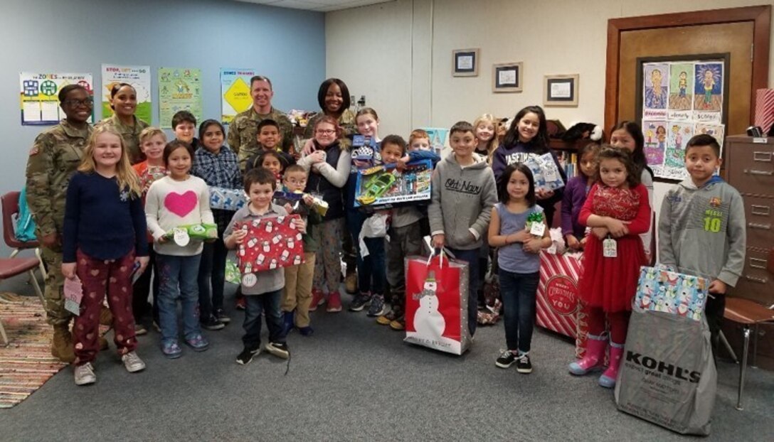 U.S. Army Reserve’s 364th Sustainment Command (Expeditionary) helped brightened the holidays of 25 local students attending Shoultes Elementary with  presentation of Christmas gifts this week as part of its 2nd annual Operation Giving Tree. For the past few weeks, ‘Sustain the Fight’ Soldiers and civilian employees collected donated items requested by the children and delivered them to the school before winter b+eak. Shoultes Elementary is part of the 364th ESC’s School Partnership Program.