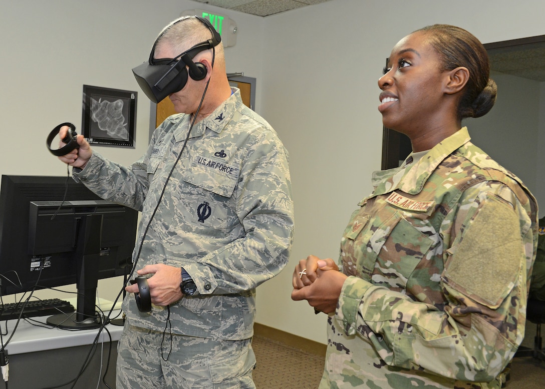 Staff Sgt. Nori Sannoh, 432nd Maintenance Group, Creech Air Force Base, Nevada, guides Col. Lawrence Havird, 412th Maintenance Group commander, in a demonstration that showed how maintainers can train using virtual reality. (U.S. Air Force photo by Kenji Thuloweit)