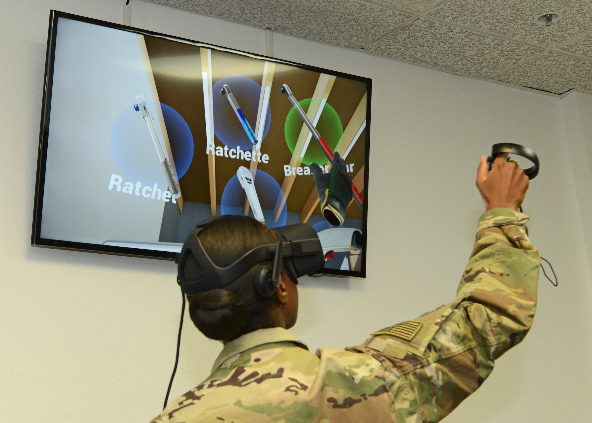 Staff Sgt. Nori Sannoh, 432nd Maintenance Group, Creech Air Force Base, Nevada, demonstrates a virtual reality program for 412th Test Wing leadership Dec. 20. Sannoh assisted with the demonstration that showed how maintainers can train using virtual reality. (U.S. Air Force photo by Kenji Thuloweit)