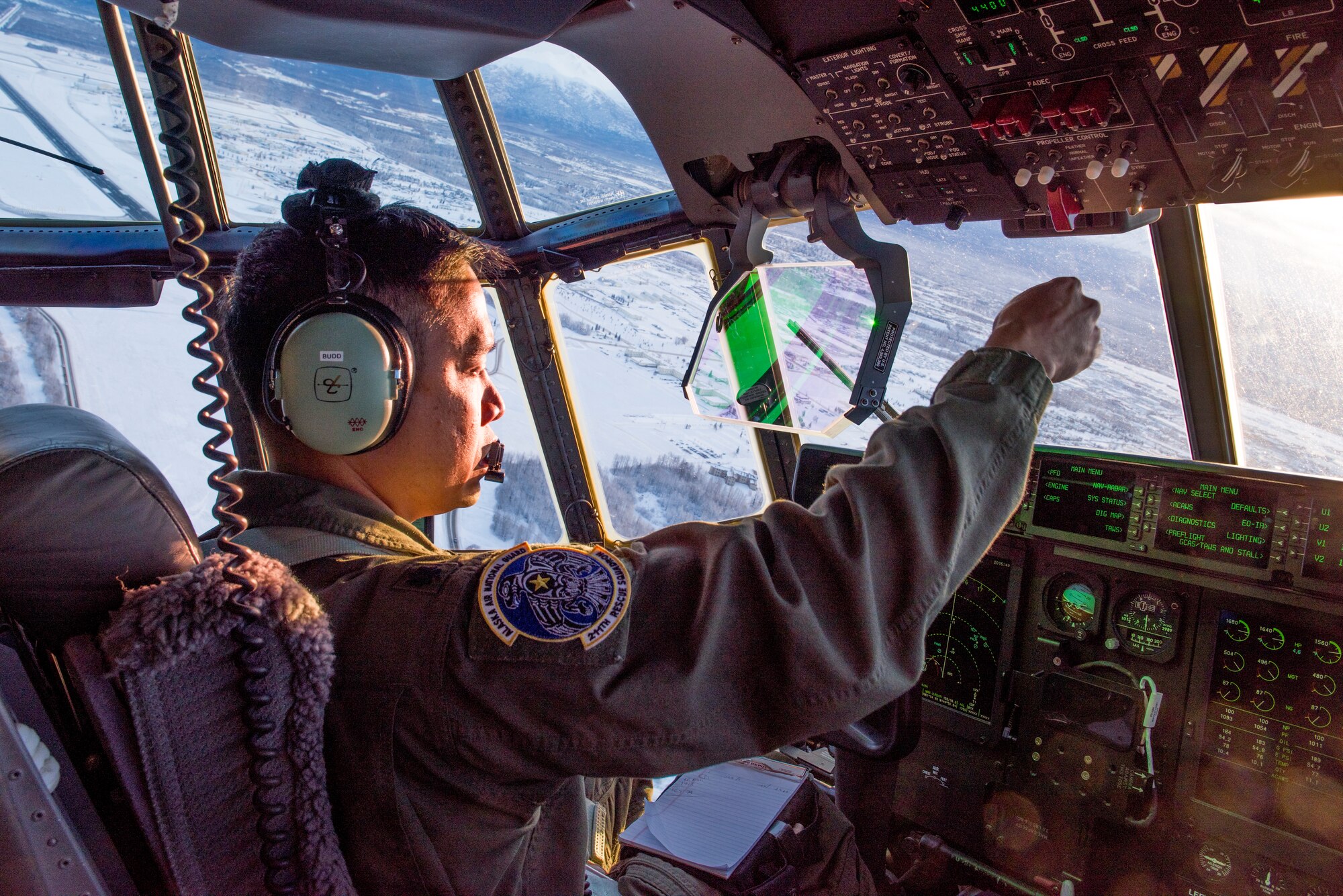 Lt.Col. Eric Budd, a pilot with the 211th Rescue Squadron, gives direction as the aircraft commander of a C130J "Combat King II" during an aerial damage assessment Nov. 30, 2018, flying over Southcentral Alaska. In a matter of hours, members of the Alaska Air National Guard's Maintenance and Operation groups turned a planned community engagement into an aerial survey of earthquake damage, reporting findings to the State of Alaska's Joint Operations Center.