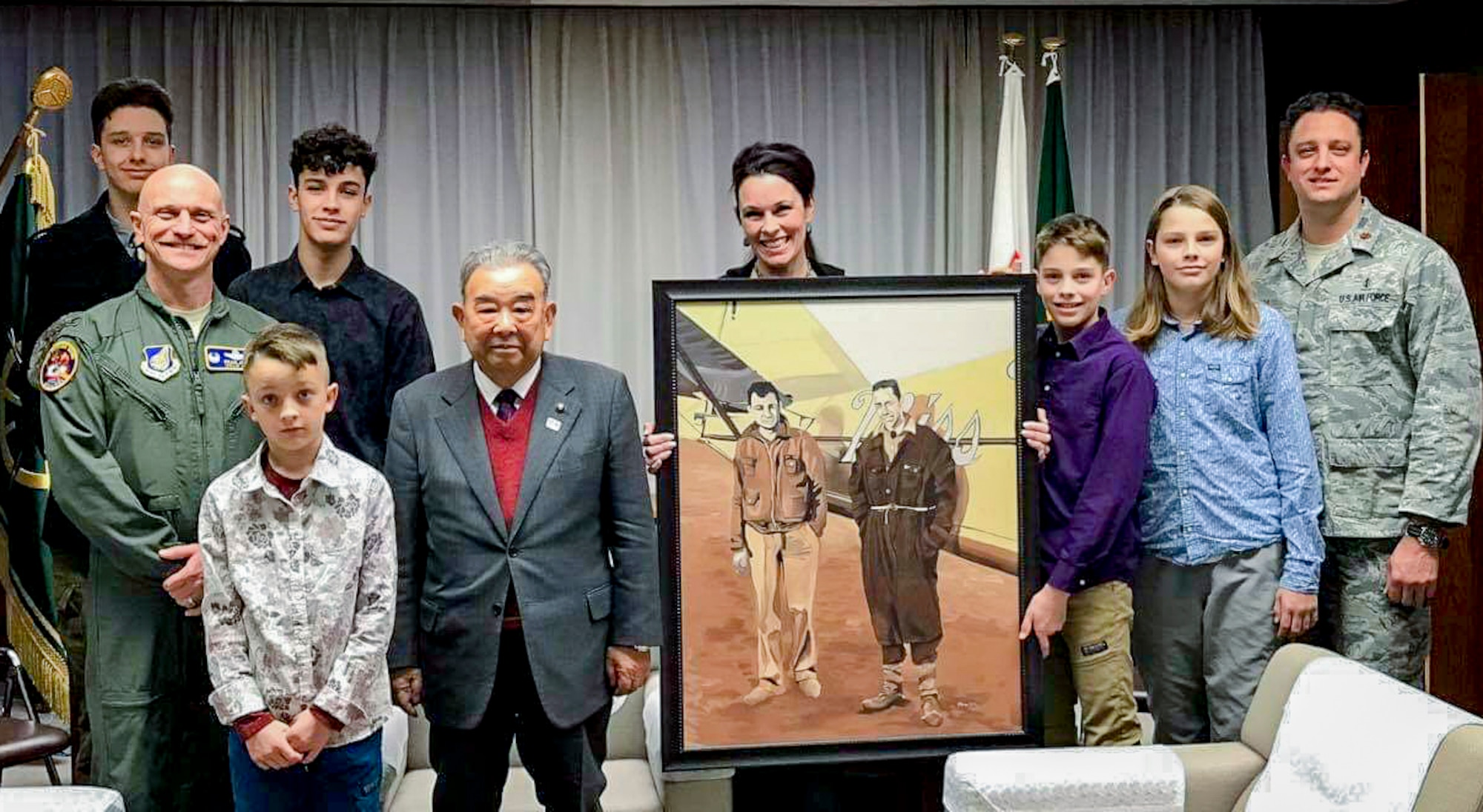 Sharon Smith, the wife of Maj. Brian Smith, a physical therapist with the 35th Medical Operations Squadron, poses for a photo with Misawa Mayor Kazumasa Taneichi and U.S. Air Force Col. R. Scott Jobe, a former 35th Fighter Wing commander, after the mayor received a photo from Smith at Misawa Air Base, Japan, in 2017. Smith owned the photo from a family relative, which detailed the two pilots of the “Miss Veedol” aircraft who made the first Trans-Pacific flight from Japan to the U.S. on Oct. 5, 1931. The gift and piece of history strengthened relations between the U.S. military community and Japan and remains in Misawa City Hall today. (Courtesy photo)