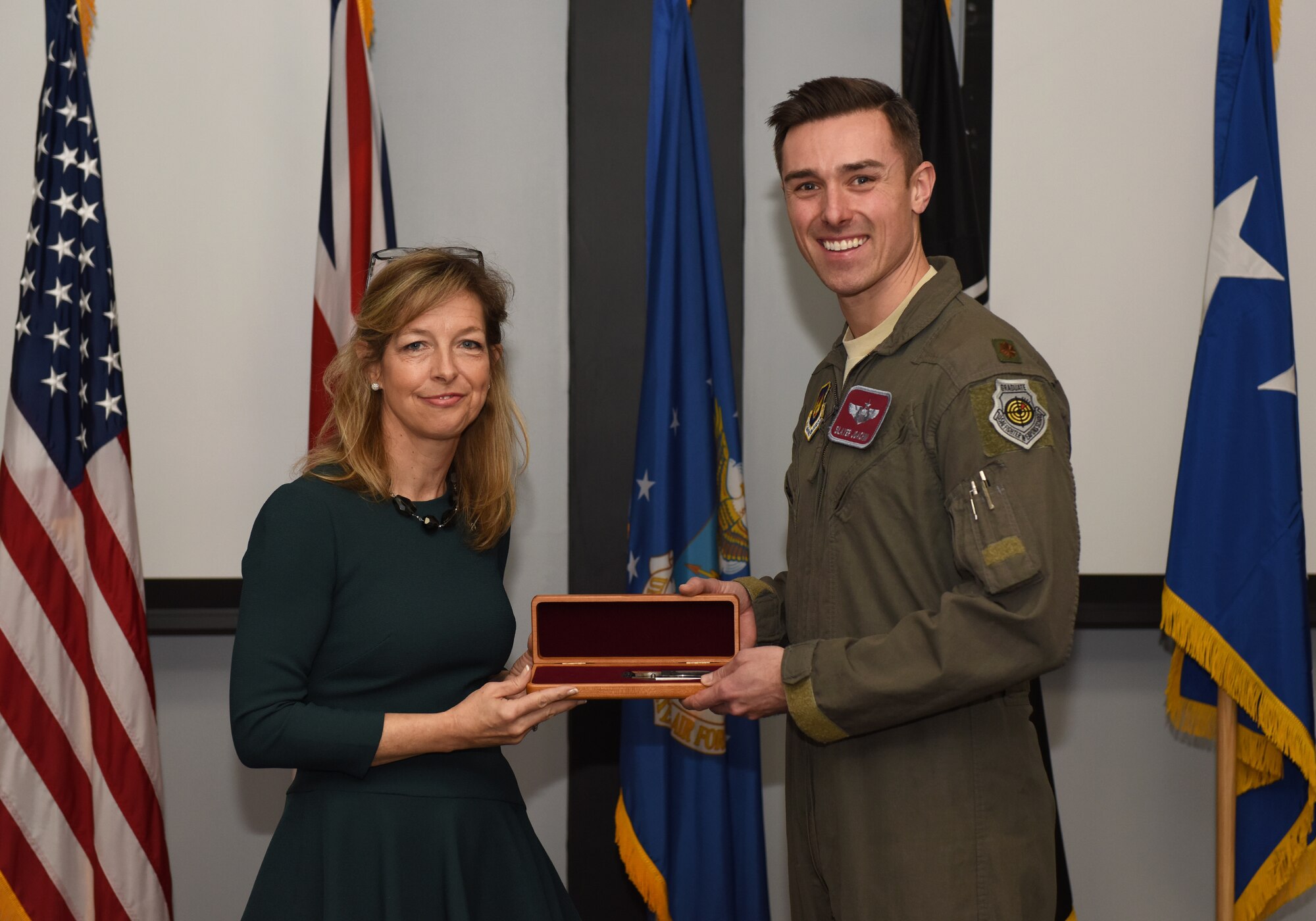 Colleen Shine presents U.S. Air Force Maj. Eric Joachim, 48th Operations Support Squadron chief of weapons, with a ceremonial knife during the presentation of the Lt. Col. Anthony C. Shine Fighter Pilot Award at Royal Air Force Lakenheath, Dec. 11, 2018. Joachim earned the prestigious award through his exceptional flying abilities, superior leadership and dedicated community involvement. (U.S. Air Force photo by Staff Sgt. Alex Echols)