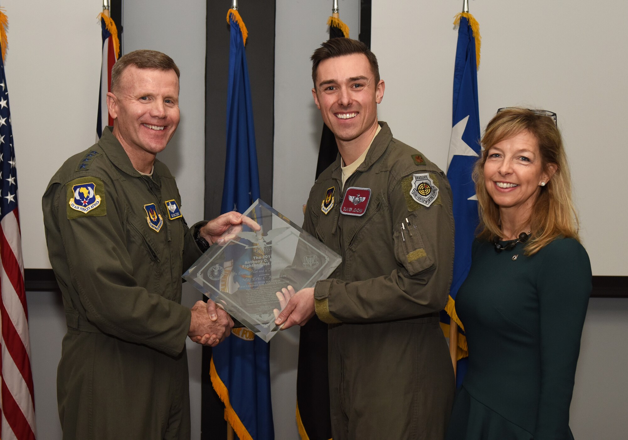 U.S. Air Force Gen. Tod D. Wolters, United States Air Forces in Europe – Air Forces Africa commander, presents Maj. Eric Joachim, 48th Operations Support Squadron chief of weapons, with the Lt. Col. Anthony C. Shine Fighter Pilot Award during a ceremony at Royal Air Force Lakenheath, Dec. 11, 2018. Joachim earned the prestigious award through his exceptional flying abilities, superior leadership and dedicated community involvement. (U.S. Air Force photo by Staff Sgt. Alex Echols)