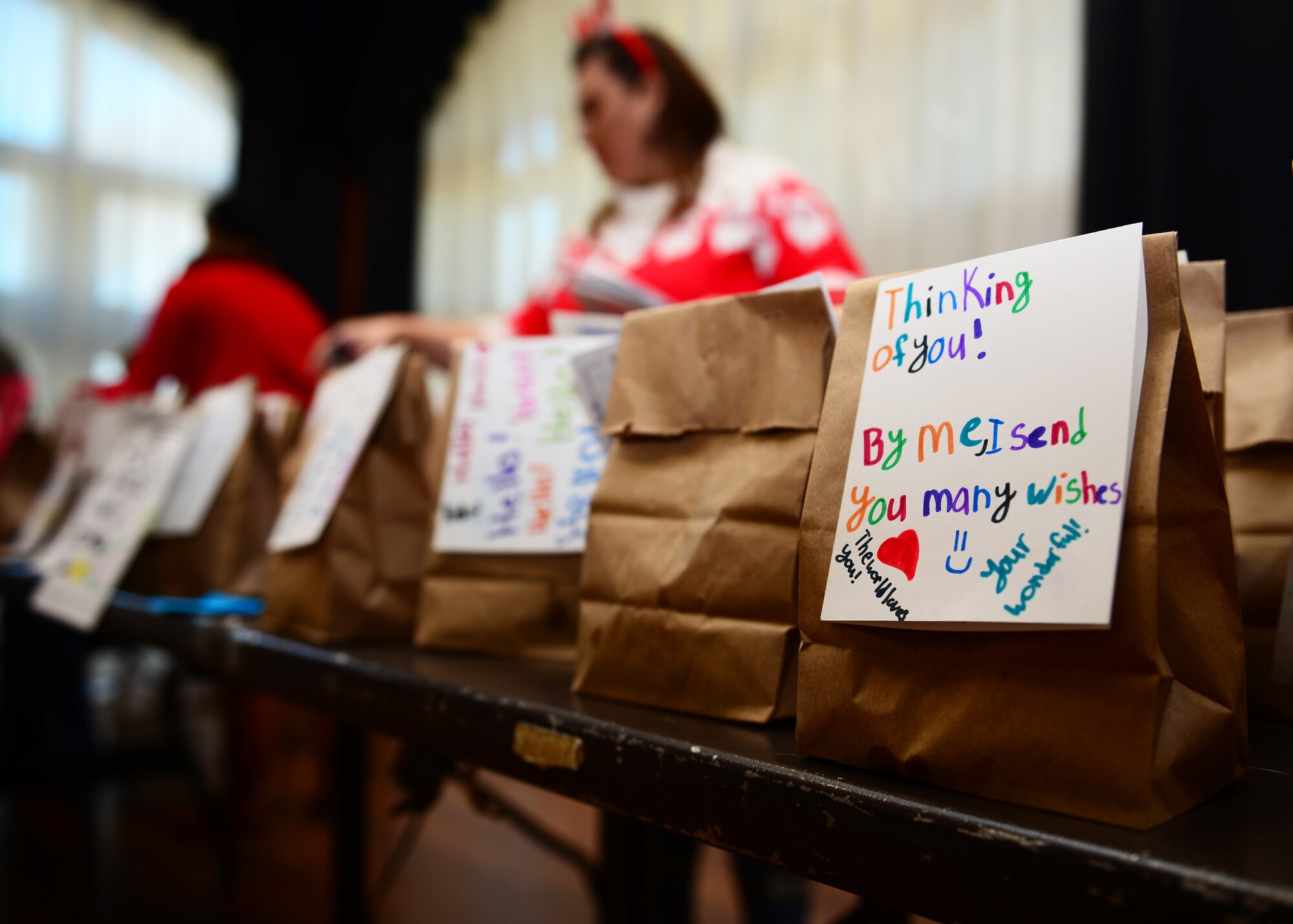 Members of the Spouses of Aviano group work together to attach holiday cards to bags of cookies during the holiday cookie drive at Aviano Air Base, Italy, Dec. 11, 2018. Approximately 25 members of the Spouses of Aviano members volunteered to help at the cookie drive.