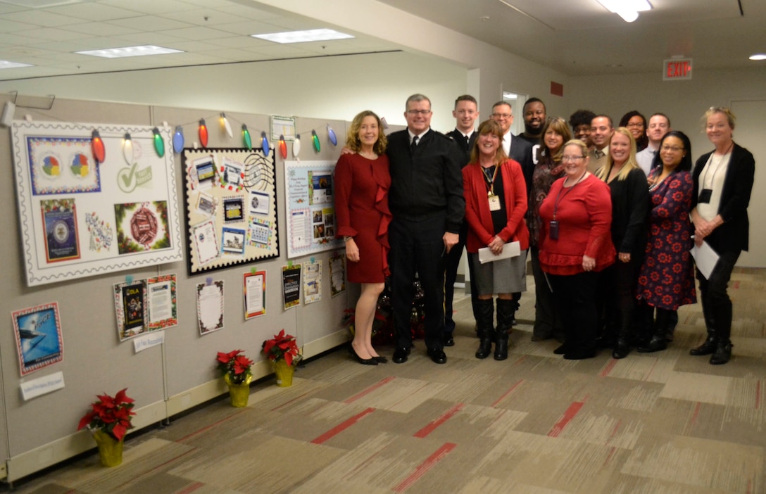 Defense Logistics Agency Troop Support leaders pose with members of the Command Support Office next to their entry in the 2018 holiday decorating contest in Philadelphia Dec. 20, 2018.