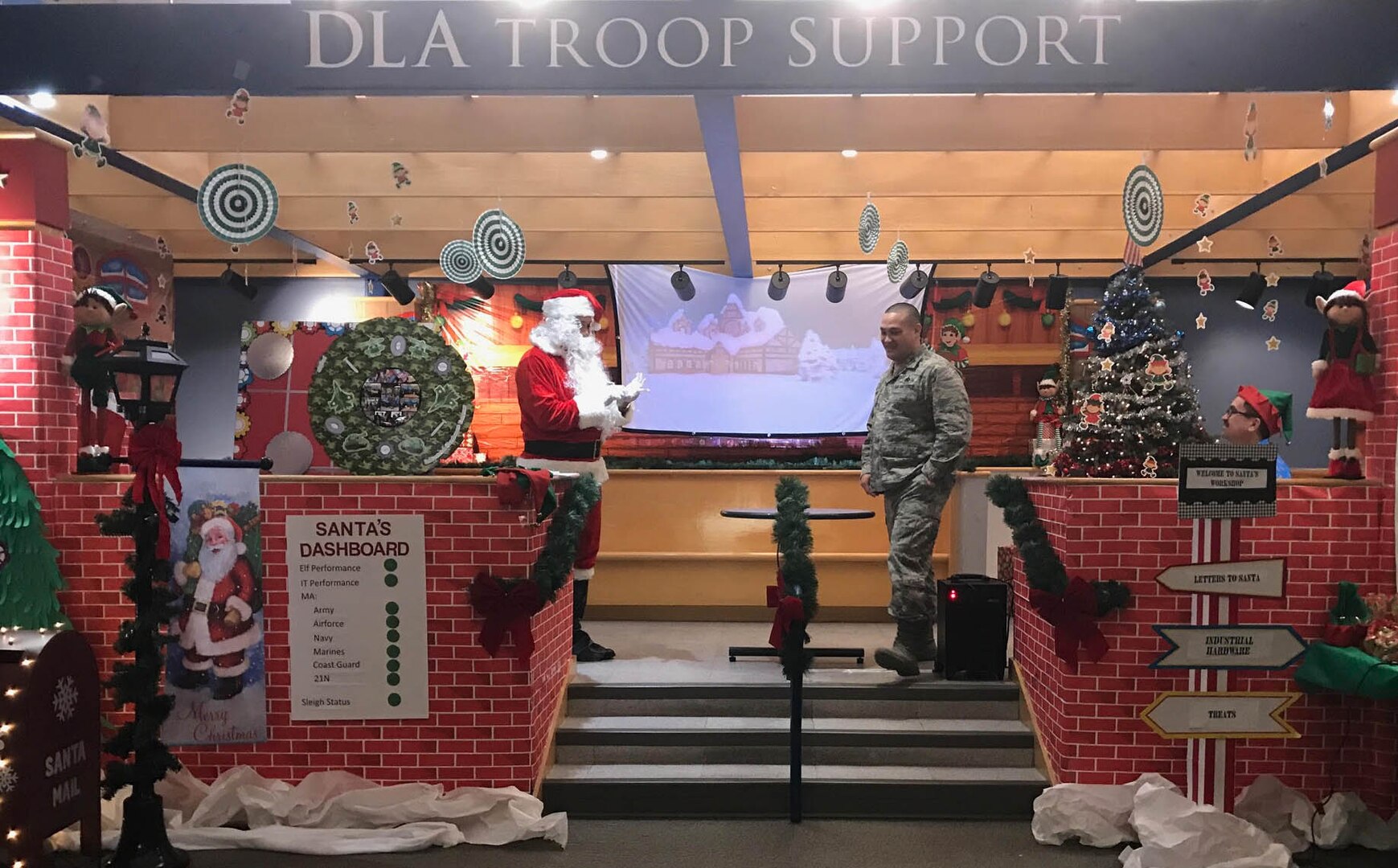 Defense Logistics Agency Troop Support Industrial Hardware Director Air Force Col. Adrian Crowley is addressed by Santa, played by contract specialist Craig Singleton, in a presentation from IH as part of their entry in the 2018 holiday decorating contest in Philadelphia Dec. 20, 2018.
