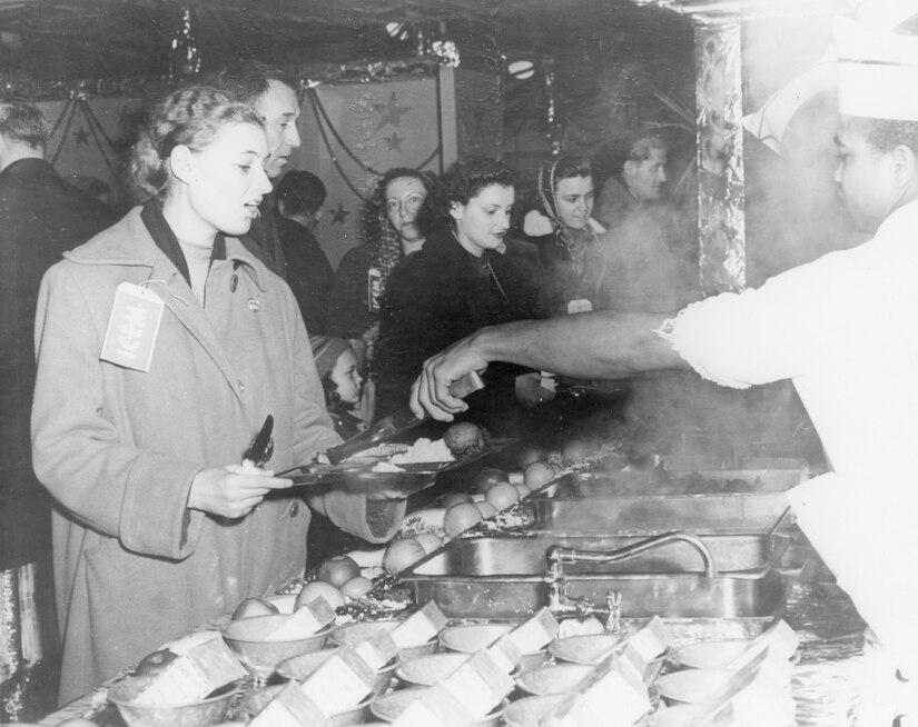 A Hungarian refugee, one of 279 who were flown out of Eastern Europe in December of 1956 by C-121s based at Charleston Air Force Base, S.C., receives a meal at the Charleston AFB dining hall.
