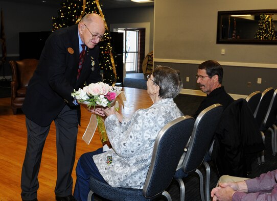 Mark Horning gives flowers to his wife Jean during his retirement Dec 18, 2018, on Columbus Air Force Base, Mississippi. (U.S. Air Force photo by Mary Crump)