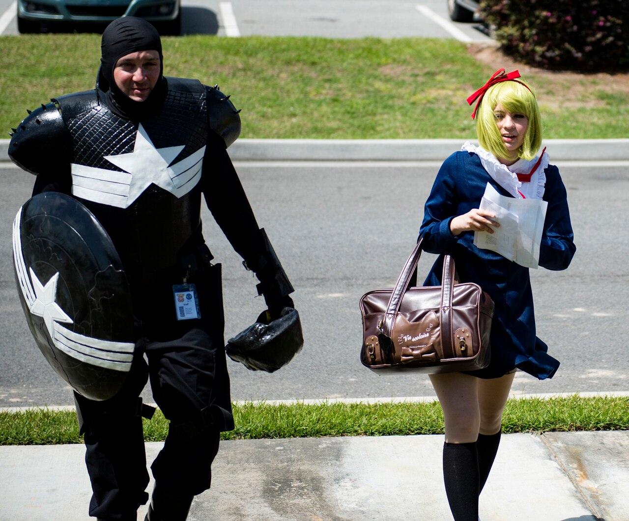 A man in a superhero costume and a woman in an anime schoolgirl costume