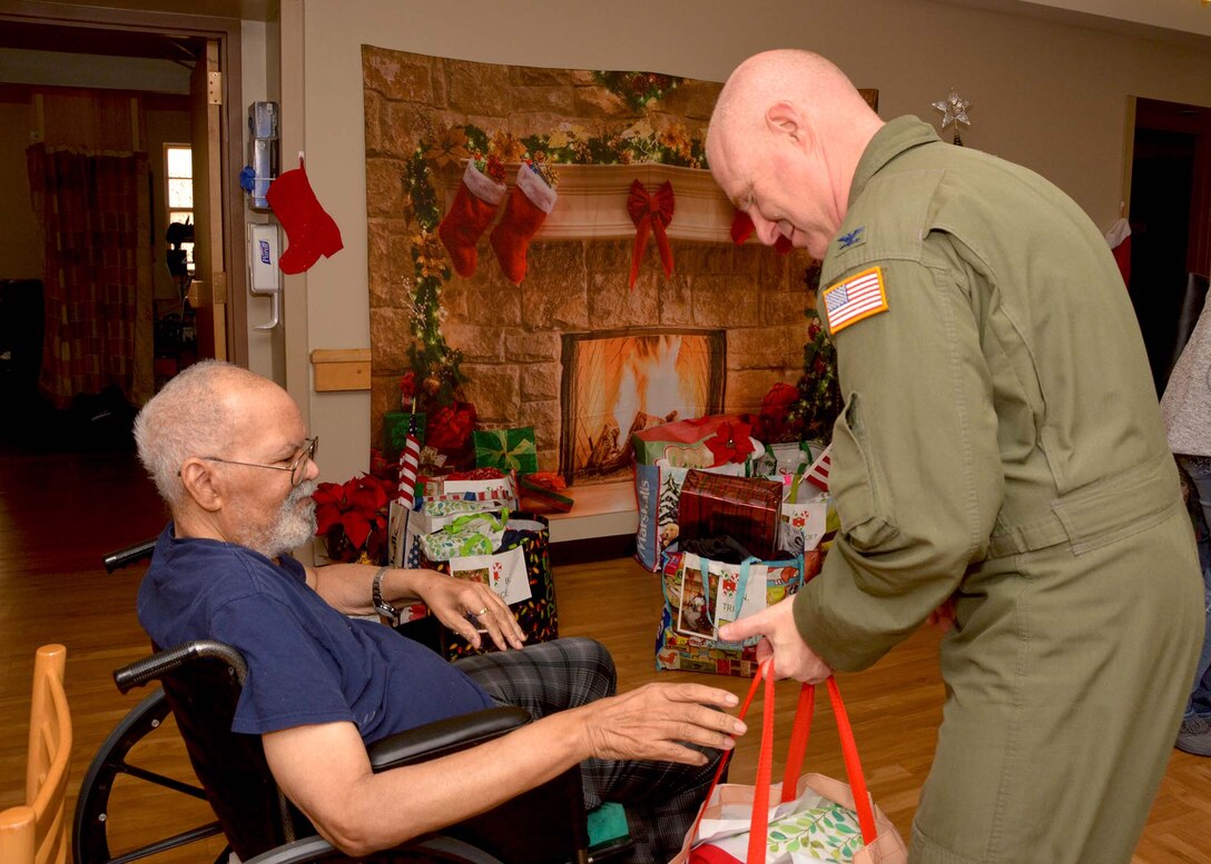 507th Air Refueling Wing Commander, Col. Miles Heaslip, helps a veteran open his gift Dec. 20, 2018, at the Norman Veterans Center in Norman, Oklahoma. 507th ARW Airmen visited the veterans to deliver gifts and serve snacks for the holidays. (U.S. Air Force photo by Tech. Sgt. Samantha Mathison)