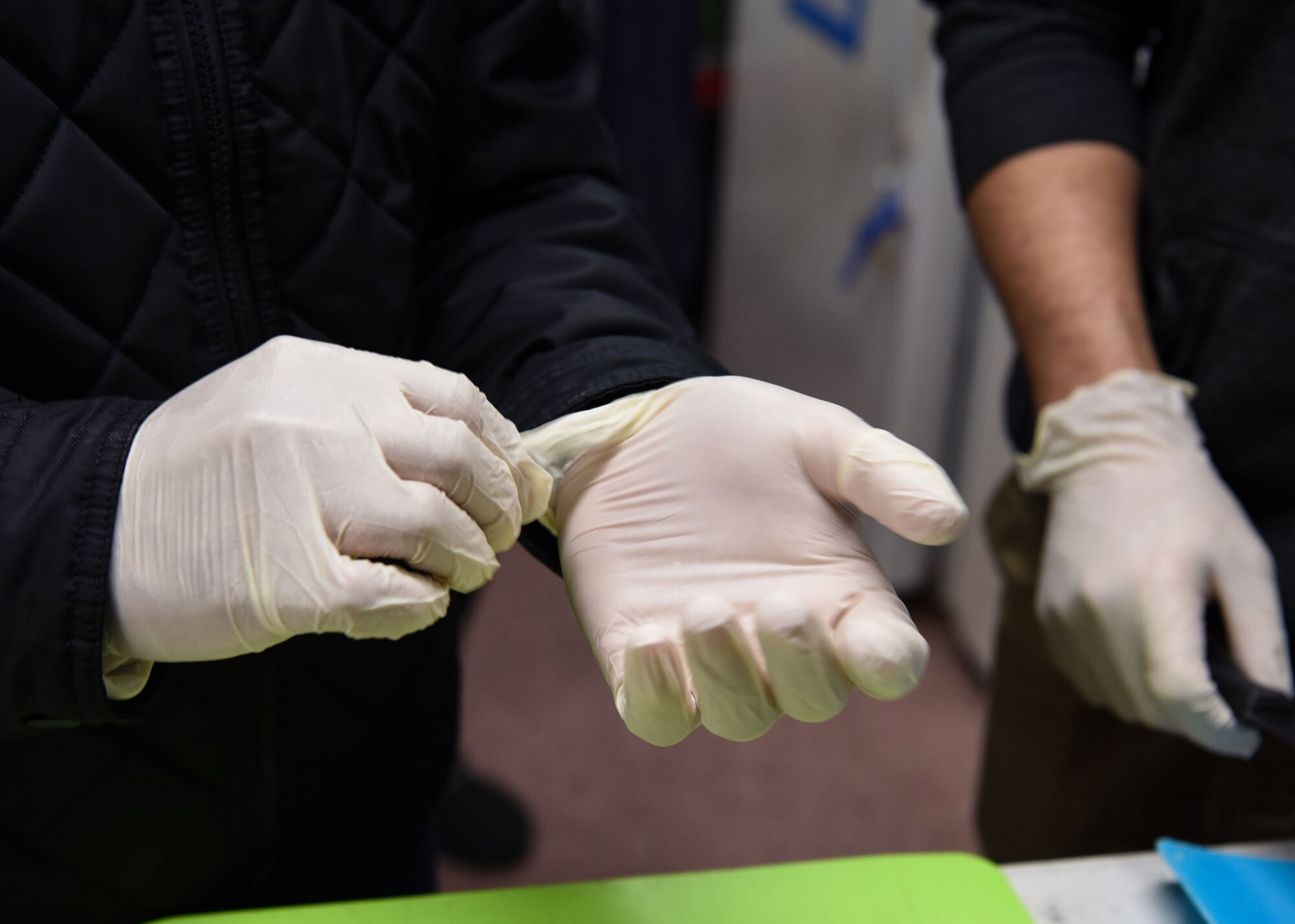A 381st Training Group technical school Airman puts on his gloves before preparing food at The Good Samaritan Bridgehouse Shelter in Lompoc, Calif. Dec. 20, 2018. While still in training, Airmen from the 381st TRG volunteer monthly at various places to comprehend the whole Airman concept.