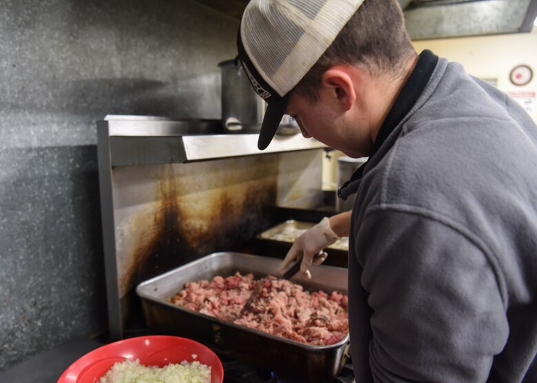A 381st Training Group technical school Airman cooks the meat for the meal at The Good Samaritan Bridgehouse Shelter in Lompoc, Calif. Dec. 20, 2018. While still in training, Airmen from the 381st TRG volunteer monthly at various places to experience the whole Airman concept.