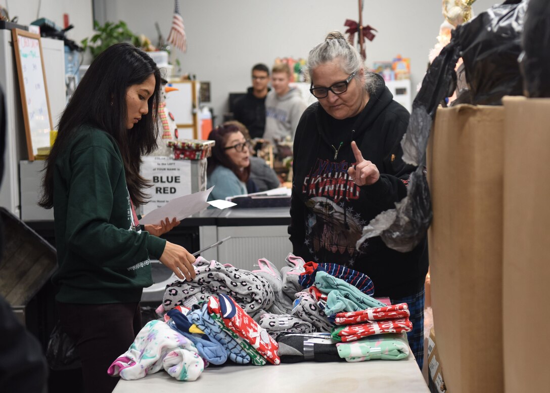A 381st Training Group technical school Airman helps a woman find clothes for her child for Christmas at The Good Samaritan Bridgehouse Shelter in Lompoc, Calif. Dec. 20, 2018. While still in training, Airmen from the 381st TRG volunteer monthly at various places to comprehend the whole Airman concept.