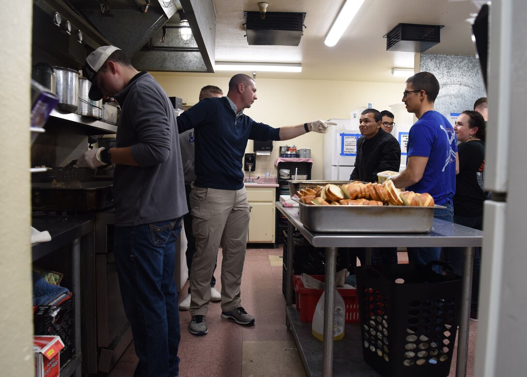Capt. Douglas Dixon, 30th Space Wing chaplain, assigns tasks and mentors Airmen while preparing food at The Good Samaritan Bridgehouse Shelter in Lompoc, Calif. Dec. 20, 2018. While still in training, Airmen from the 381st Training Group volunteer monthly at various places to comprehend the whole Airman concept.