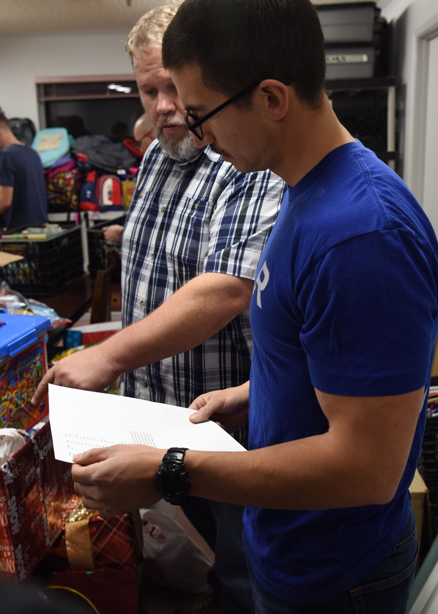 Brian Halterman, The Good Samaritan Bridgehouse Shelter director, shows an Airman volunteering from the 381st Training Group the list of items that need to be distributed at the shelter in Lompoc, Calif. Dec. 20, 2018. While still in training, Airmen from the 381st TRG volunteer monthly at various places to comprehend the whole Airman concept.