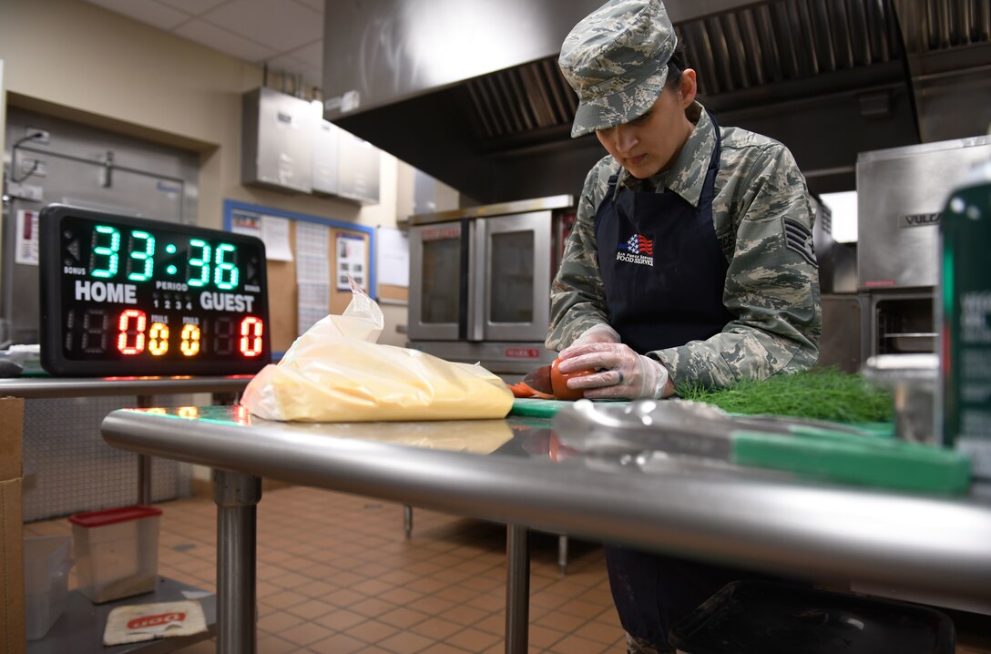 Staff Sgt. Erica Restemayer, a 28th Force Support Squadron noncommissioned officer in charge of retentions and promotions, races against the clock during the Chef of the Quarter cook-off competition at the Raider Café on Ellsworth Air Force Base, S.D., Dec. 18, 2018. Contestants were split into three teams that included one food service Airman and one volunteer NCO. (U.S. Air Force photo by Airman 1st Class Christina Bennett)