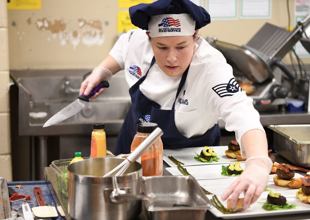 Staff Sgt. Amanda Williams, a 28th Force Support Squadron food services specialist, begins plating her meal at the Chef of the Quarter cook-off held at the Raider Café on Ellsworth Air Force Base, S.D., Dec. 18, 2018. Each team needed to create three plates for the judges and one for the presentation table.  (U.S. Air Force photo by Airman 1st Class Christina Bennett)