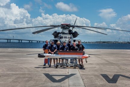 The AN/AQS-24C Mine Detecting Set Airborne Mine Countermeasures In-Service Engineering Activity test team posed for a photo at the conclusion of a successful test event in Panama City, Florida. Pictured from left to right are: Mark Gibbons, Naval Surface Warfare Center Panama City Division (NSWC PCD), Jason Niemczura (NSWC PCD), Kelly Williams (NSWC PCD), Corey Fife (NSWC PCD), Justin Grimes (NSWC PCD), Brett Thach (NSWC PCD), and Gregg Volpe (Northrop Grumman). U.S. Navy photo by Anthony Powers.