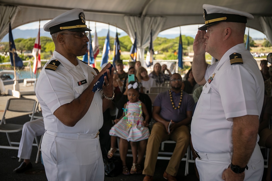 U.S. Navy Lt. Cmdr. Phillip Ridley, Marine Corps Base Hawaii chaplain, receives a retirement flag from Lt. Cmdr. Buster Williams, Marine Aircraft Group 24 chaplain, during Ridley’s retirement ceremony on the USS Missouri, Pearl Harbor, Dec. 20, 2018. Ridley retired after 29 years of faithful service to the U.S. Navy. (U.S. Marine Corps photo by Sgt. Zachary Orr)