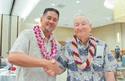 Lewis Walters (right), son of George S.B. Walters, congratulates Dale Hoxie, an electrician supervisor of PHNSY/IMF.