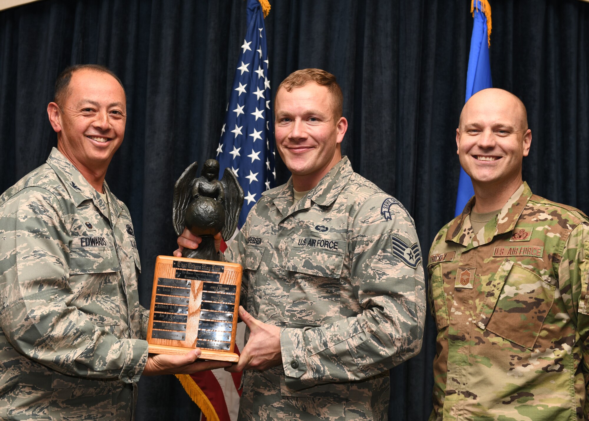 Col. John Edwards and Chief Master Sgt. Jason Trickey present Staff Sgt. Dustin Jespersen with the 2018 Air Association Richard T. Kight Award at the Dakota’s Club on Ellsworth Air Force Base, S.D., Oct. 31, 2018. Edwards is the 28th Bomb Wing commander; Jespersen is a 28th Operations Squadron survival, evasion, resistance and escape specialist; and Trickey is the 28th Operations Group superintendent. After being awarded the 2018 Air Rescue Association Richard T. Kight Award, Jespersen was promoted to technical sergeant as part of the Stripes for Exceptional Performers (STEP) program. (U.S. Air Force photo by Airman 1st Class Thomas Karol)