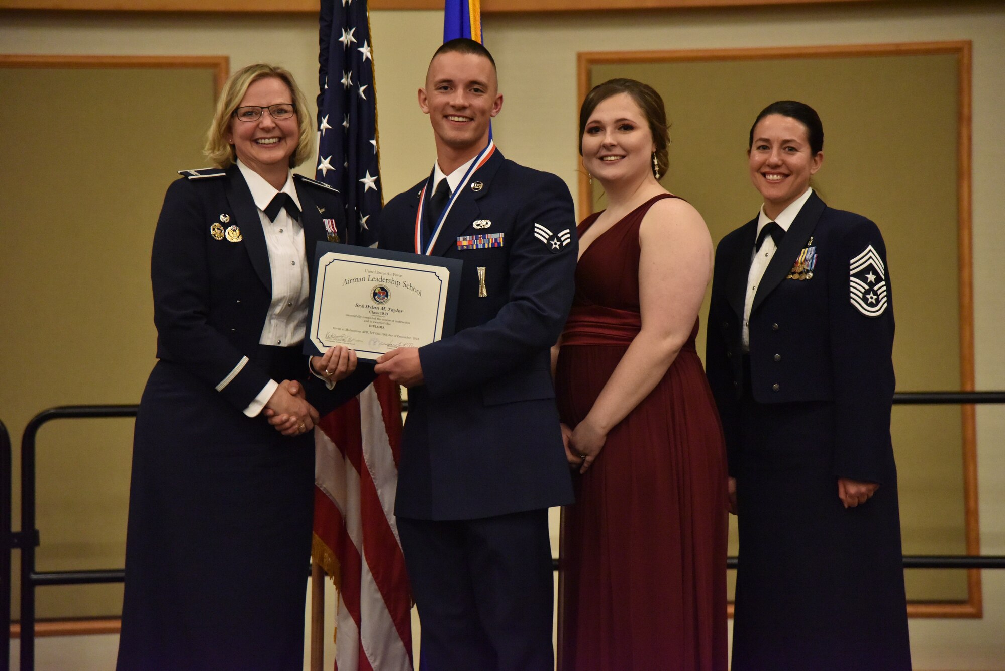 Col. Jennifer Reeves, 341st Missile Wing commander, left, Senior Airman Dylan Taylor, 341st Missile Maintenance Squadron, Mrs. Dylan Taylor and Chief Master Sgt. Eryn McElroy, 341st MW command chief, pose for a photo Dec. 19, 2018, at Malmstrom Air Force Base, Mont. Dylan received the 341st Force Support Squadron Airman Leadership School Class 19-B John L. Levitow Award. (U.S. Air Force by Senior Airman Magen M. Reeves)