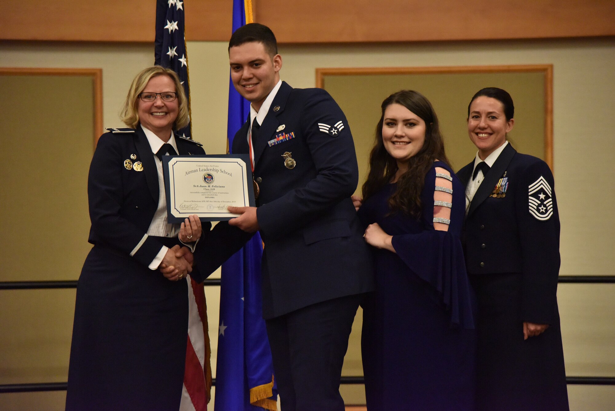 Col. Jennifer Reeves, 341st Missile Wing commander, left, Senior Airman Juan Feliciano, 341st Missile Security Forces Squadron, Mrs. Juan Feliciano and Chief Master Sgt. Eryn McElroy, 341st MW command chief, pose for a photo Dec. 19, 2018, at Malmstrom Air Force Base, Mont. Juan received a 341st Force Support Squadron Airman Leadership School Class 19-B Distinguished Graduate Award. (U.S. Air Force by Senior Airman Magen M. Reeves)