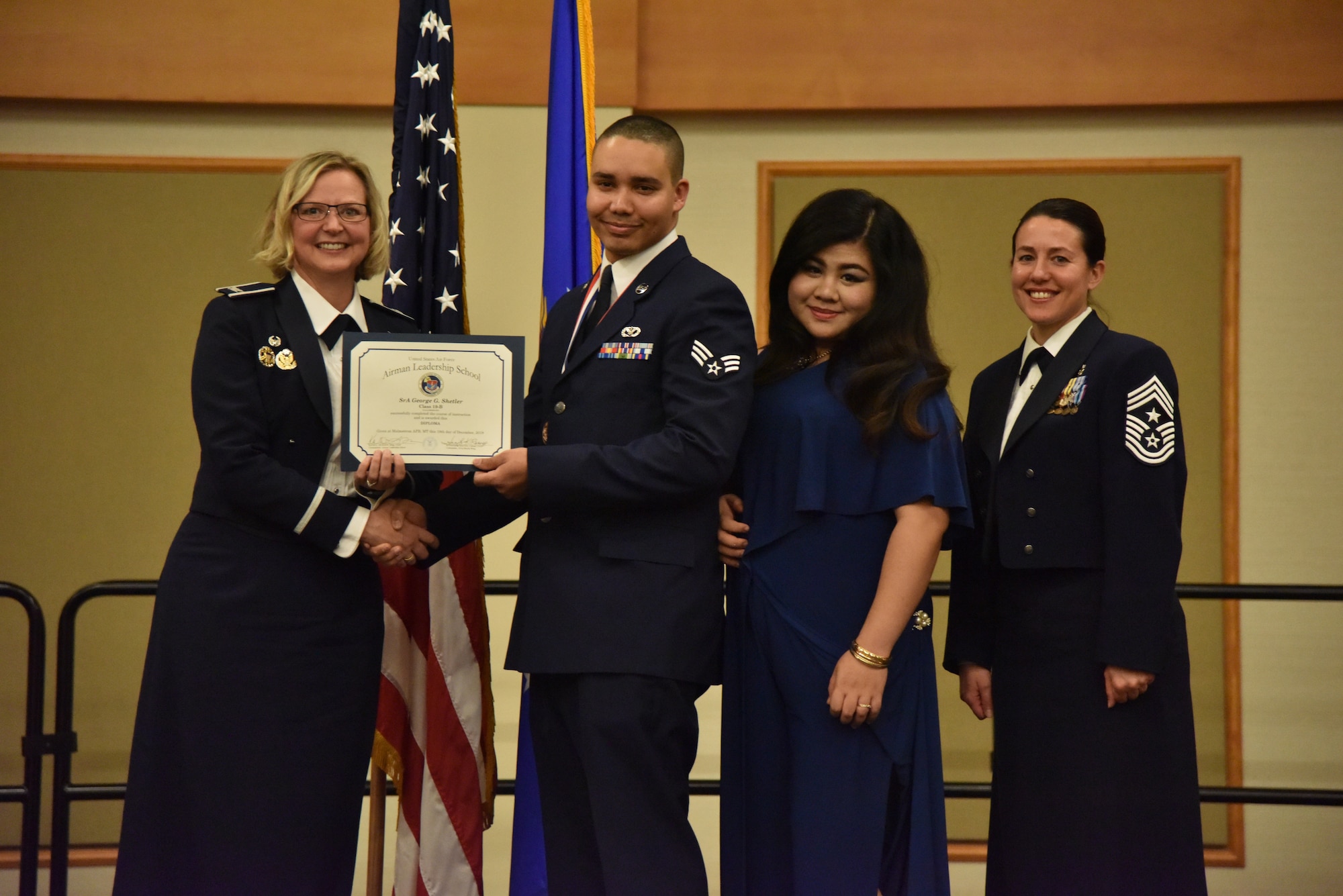 Col. Jennifer Reeves, 341st Missile Wing commander, left, Senior Airman George Shetler, 819th Rapid Engineer Deployable Heavy Operation Repair Squadron Engineer (RED HORSE), Mrs. George Shetler and Chief Master Sgt. Eryn McElroy, 341st MW command chief, pose for a photo Dec. 19, 2018, at Malmstrom Air Force Base, Mont. George received the 341st Force Support Squadron Airman Leadership School Class 19-B Commandant Award. (U.S. Air Force by Senior Airman Magen M. Reeves)