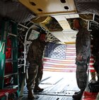 U.S. Air Force Lt. Col. Ronald Chastain, Joint Task Force Civil Support Chief of Current Operations, holds a flag with U.S. Army Col. Eric. J. Oh, JTF-CS, Director of Operations on a CH-47F flight as part of his retirement in military service of 37 years flying over the James River near Fort Eustis, Va., Dec. 21, 2018. The JTF-CS exercised a proof of concept operation using a CH-47F to transport vehicles, equipment and personnel. During the operation Chastain was honored for his dedication and service. (DoD photo by U.S. Air Force Michael Campbell/ Released)