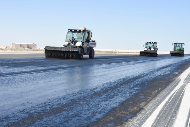The 577th Expeditionary Prime Beef Squadron agitate Avion on the runway during the rubber removal process at Al Dhafra Air Base, United Arab Emirates.