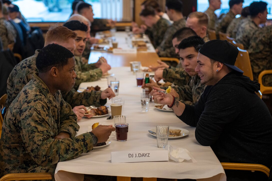 DJ J.Dayz sits and eats with troops in a dining hall.
